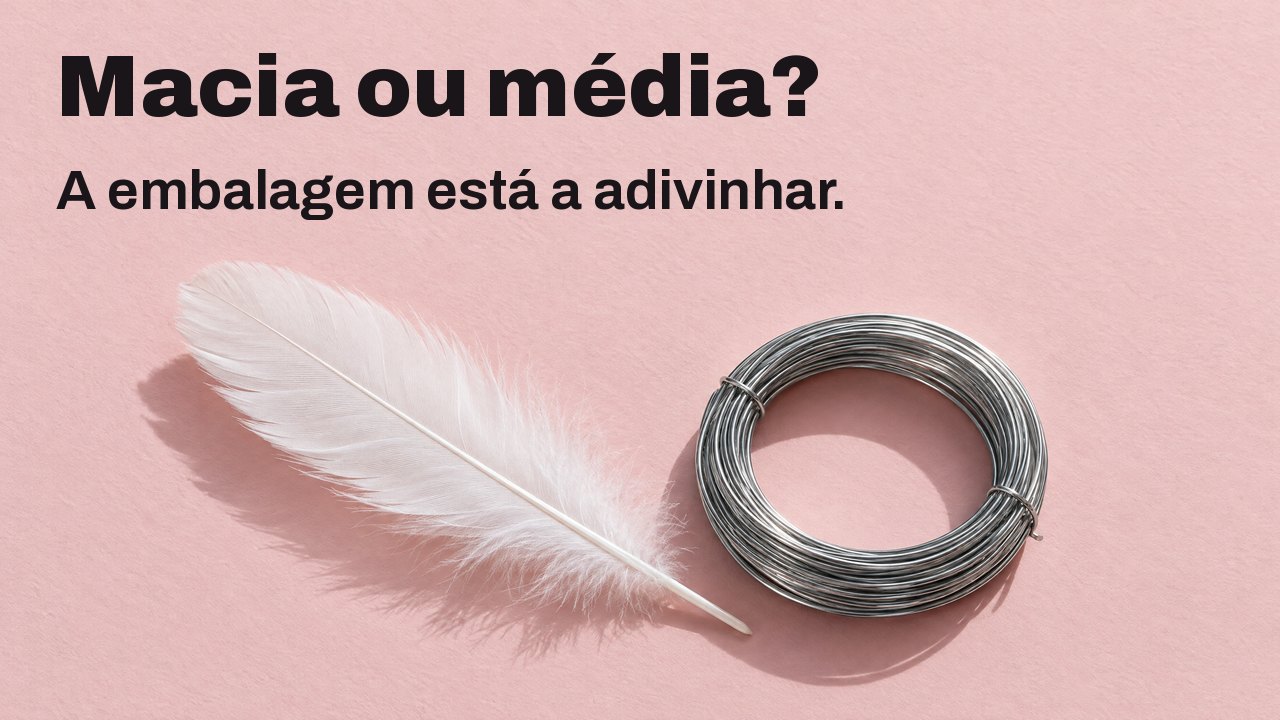 Macia ou média? A embalagem está a adivinhar. Visto de cima: uma pena branca e macia ao lado de um rolo apertado de arame de aço rígido sobre papel rosa pálido.