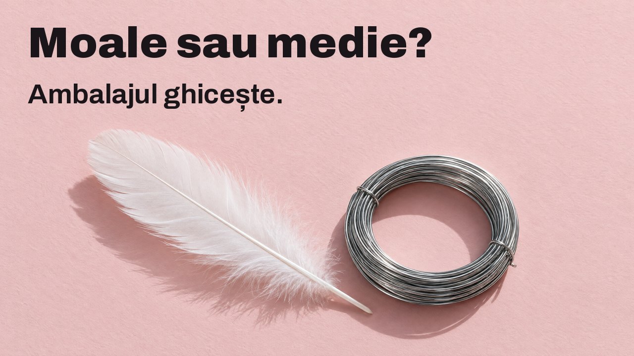 Moale sau medie? Ambalajul ghicește. Văzut de sus: o pană albă și moale lângă un colac strâns de sârmă rigidă de oțel, pe hârtie roz pal.