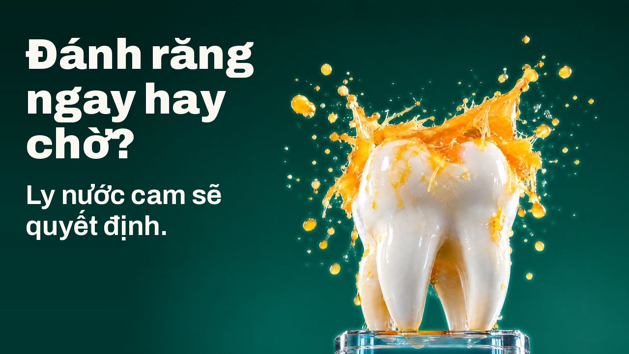 Đánh răng ngay hay chờ? Ly nước cam sẽ quyết định. Một tượng răng màu trắng trên đế thủy tinh, dưới tia nước cam bắn tung tóe đông cứng giữa không trung, trên nền studio xanh lục đậm.