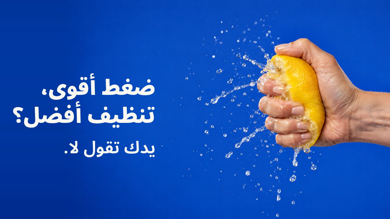ضغط أقوى، تنظيف أفضل؟ يدك تقول لا. يد تعصر ليمونة بقوة حتى ينفجر عصيرها رذاذًا متجمّدًا، على أزرق كوبالتي.