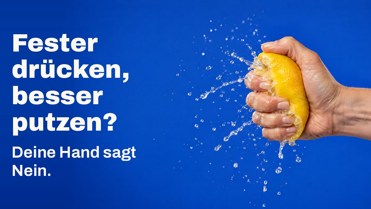 Fester drücken, besser putzen? Deine Hand sagt Nein. Eine Hand presst eine Zitrone so fest, dass der Saft in einem erstarrten Sprühnebel herausschießt, vor Kobaltblau.