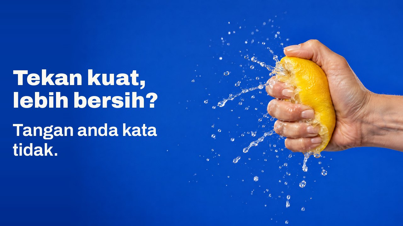 Tekan kuat, lebih bersih? Tangan anda kata tidak. Tangan memerah lemon begitu kuat sehingga jusnya memancut dalam semburan yang membeku, berlatarkan biru kobalt.
