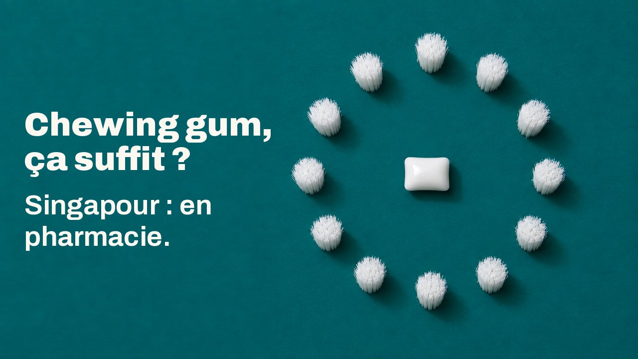 Chewing gum, ça suffit ? Singapour : en pharmacie. Vue du dessus sur un fond bleu canard profond : une dragée blanche de chewing gum repose au centre d’un anneau parfait de touffes de poils blancs, comme un cadran d’horloge sans aiguilles.