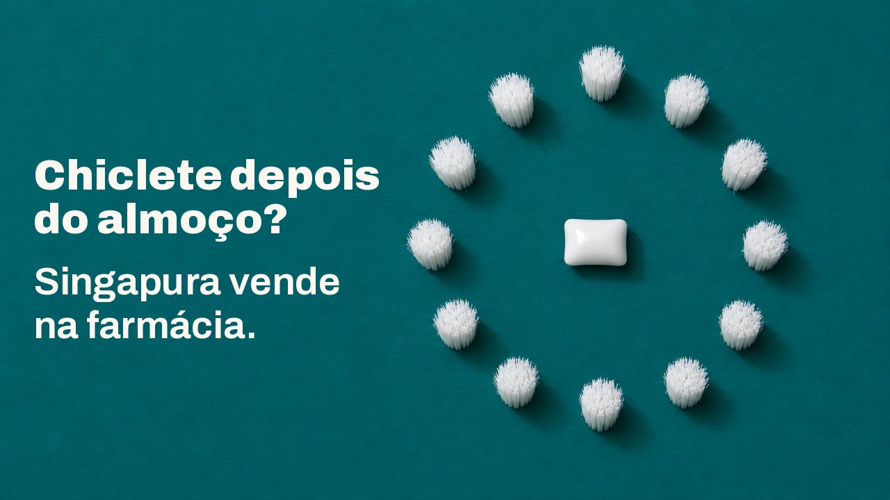 Chiclete depois do almoço? Singapura vende na farmácia. Visto de cima sobre um fundo azul petróleo profundo: uma drágea branca de chiclete está no centro de um anel perfeito de tufos de cerdas brancas, como um mostrador de relógio sem ponteiros.