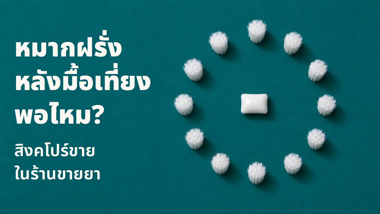 หมากฝรั่งหลังมื้อเที่ยงพอไหม? สิงคโปร์ขายในร้านขายยา มองลงมาจากด้านบนตรง ๆ บนพื้นสีเขียวหัวเป็ดเข้ม: เม็ดหมากฝรั่งสีขาวเม็ดเดียววางอยู่กลางวงกลมสมบูรณ์ของกระจุกขนแปรงสีขาว เหมือนหน้าปัดนาฬิกาที่ไม่มีเข็ม