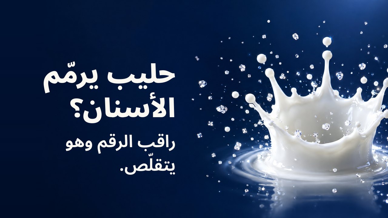 حليب يرمّم الأسنان؟ راقب الرقم وهو يتقلّص. تاج من قطرة حليب متجمّد في الهواء مع بلّورات صغيرة متلألئة، على خلفية كحلية داكنة.