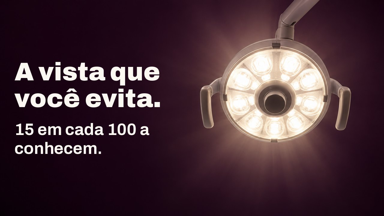 A vista que você evita. 15 em cada 100 a conhecem. A vista da cadeira do dentista, olhando direto para cima: uma luminária odontológica redonda brilha em branco quente contra um teto berinjela profundo.
