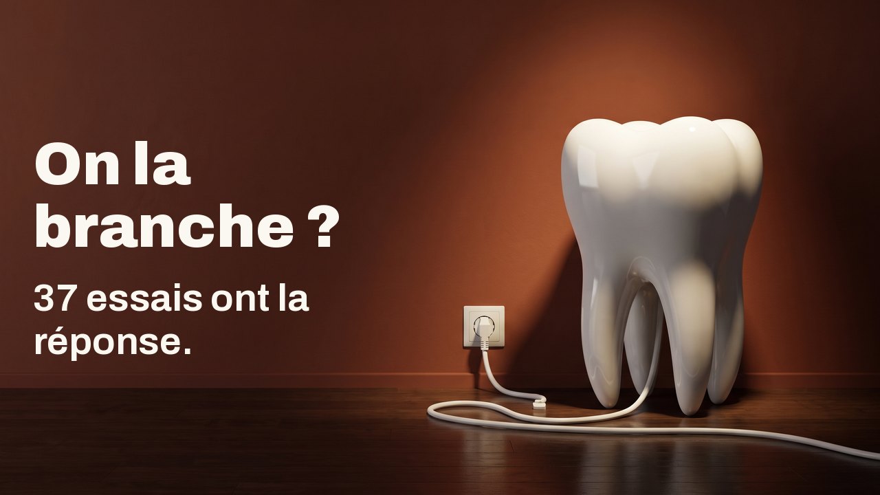 On la branche ? 37 essais ont la réponse. Une maquette de dent en porcelaine blanche sur un parquet devant un mur terracotta, son câble blanc branché dans une prise murale.