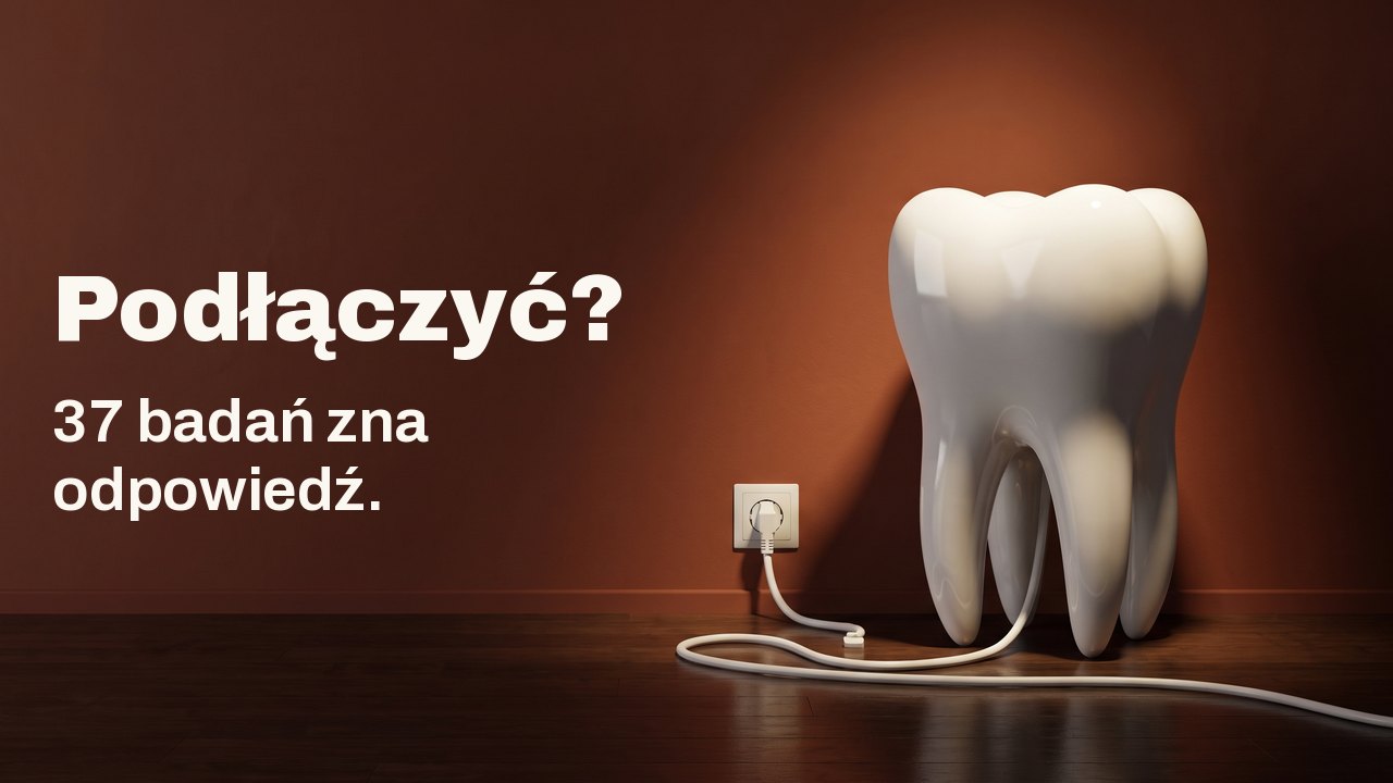 Podłączyć? 37 badań zna odpowiedź. Biały porcelanowy model zęba na drewnianej podłodze przy ścianie w kolorze terakoty, jego biały kabel jest wpięty do gniazdka w ścianie.