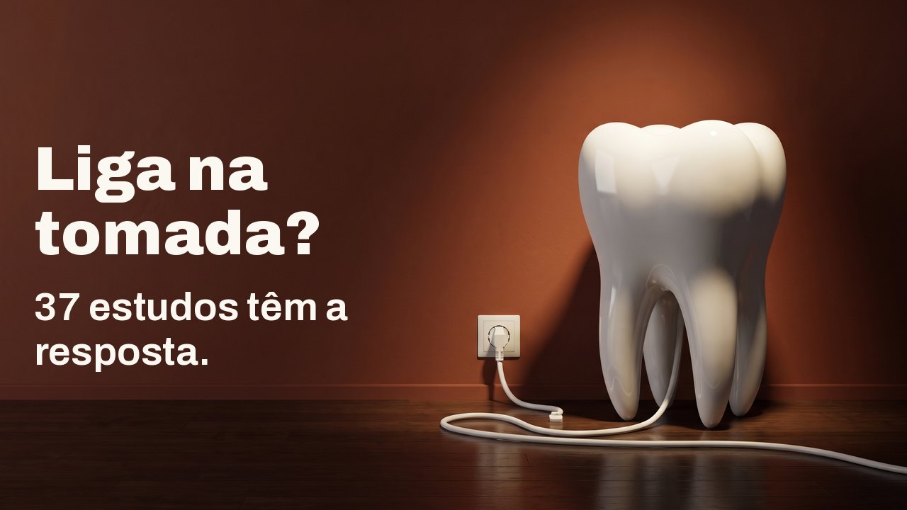 Liga na tomada? 37 estudos têm a resposta. Um modelo de dente de porcelana branca sobre um piso de madeira diante de uma parede terracota, com o cabo branco ligado na tomada da parede.