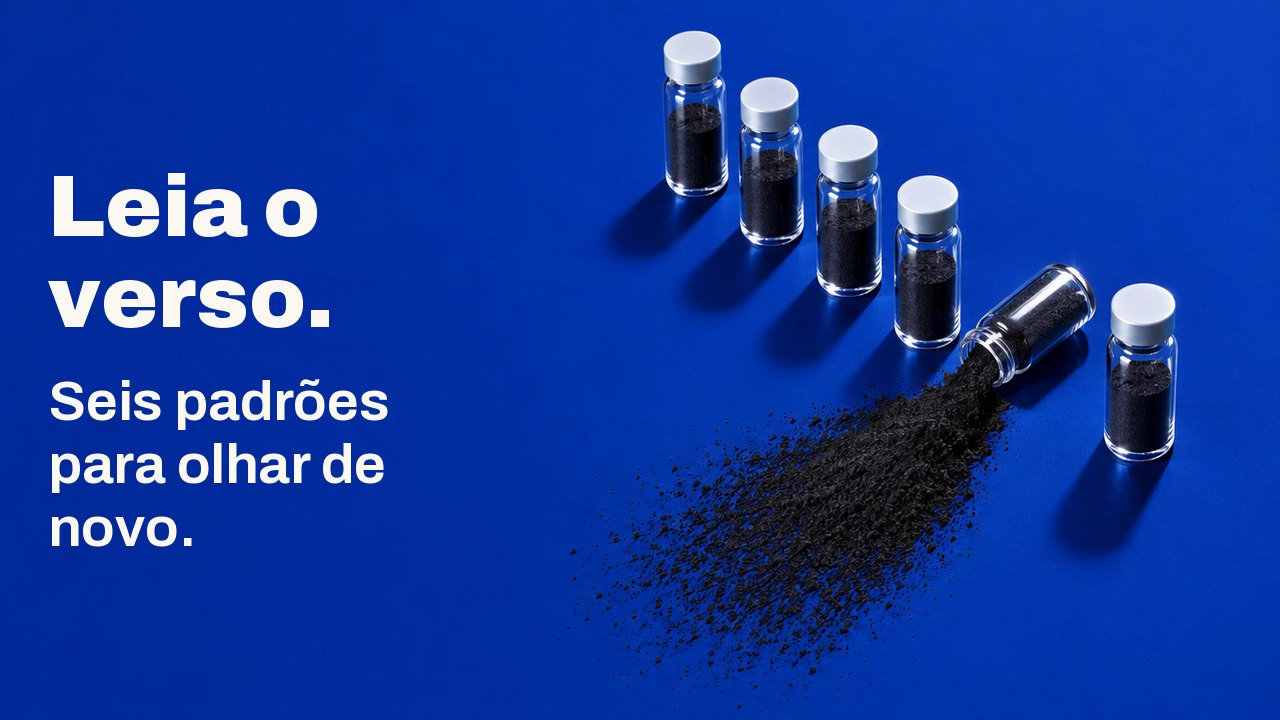 Leia o verso. Seis padrões para olhar de novo. Visto de cima sobre uma superfície azul cobalto profundo: seis frasquinhos de vidro enfileirados, e um deles tombado, espalhando um leque de pó de carvão preto.