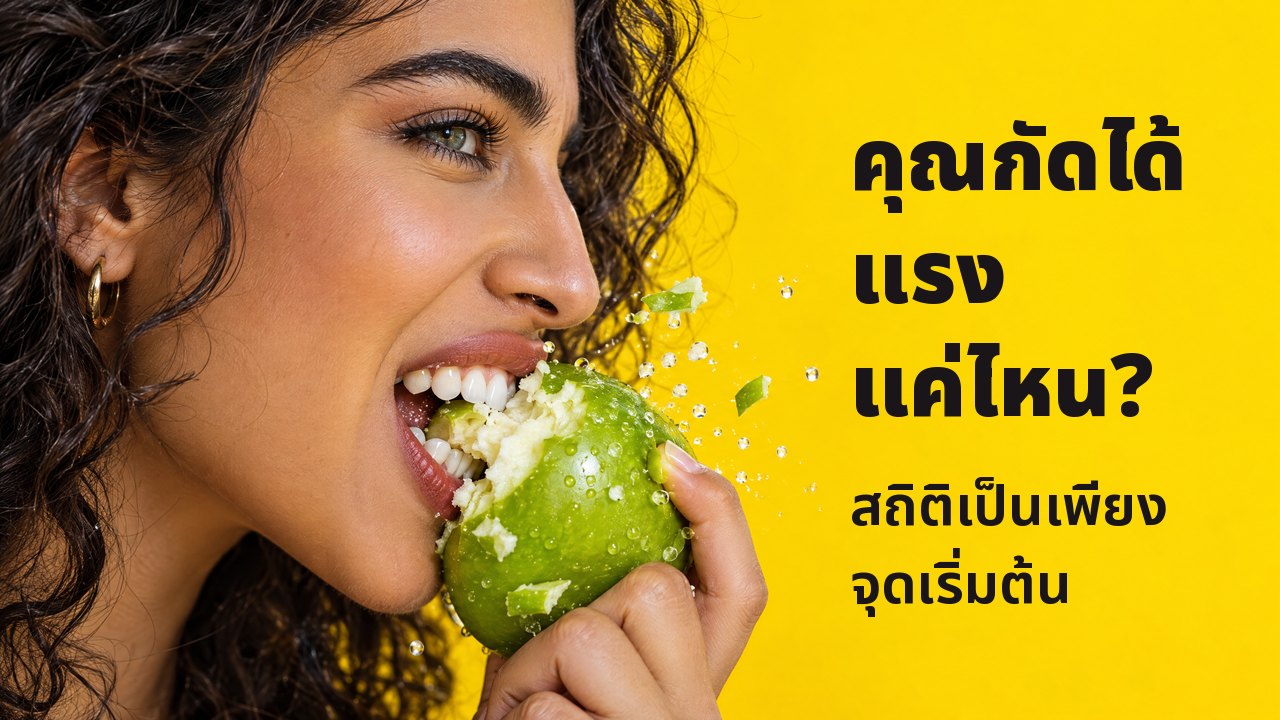 คุณกัดได้แรงแค่ไหน? สถิติเป็นเพียงจุดเริ่มต้น ภาพด้านข้างระยะใกล้ของผู้หญิงกัดแอปเปิลเขียวกรอบอย่างแรง เศษกระเด็น บนพื้นหลังสีเหลืองสด