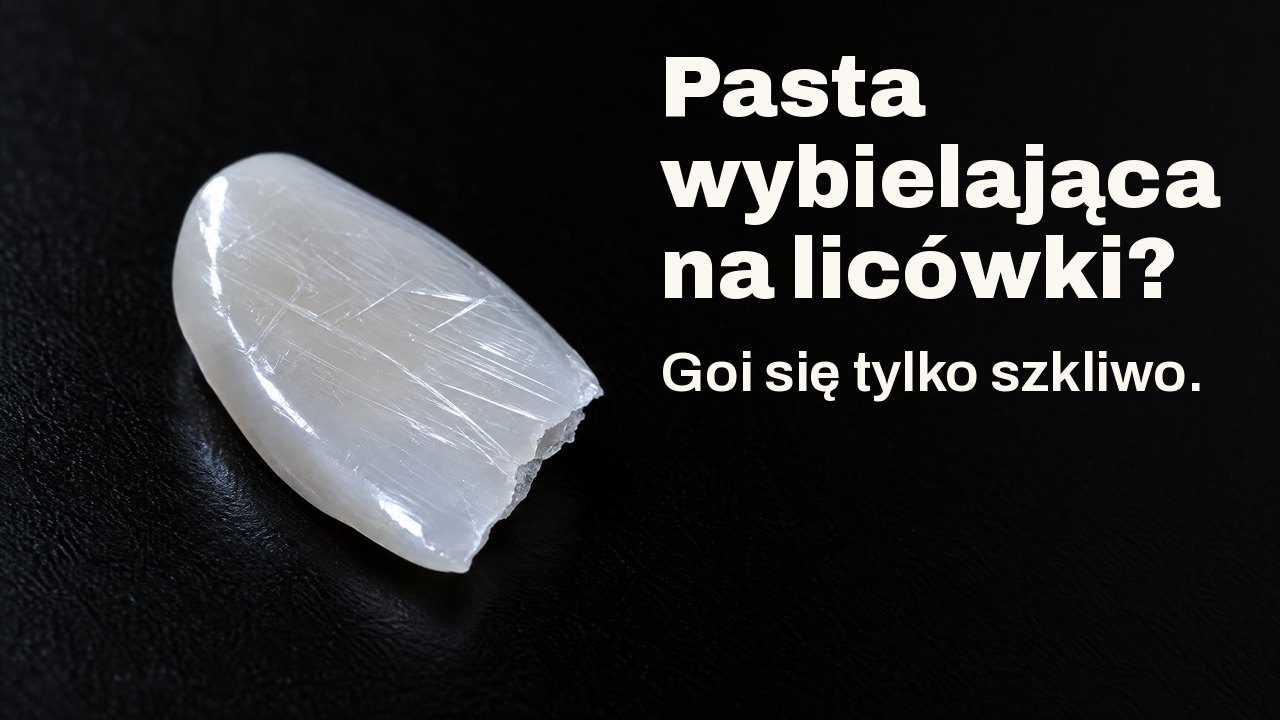 Pasta wybielająca na licówki? Goi się tylko szkliwo. W świetle bocznym: cienki lśniący odłamek porcelany jak licówka, pokryty drobnymi rysami, na czarnym tle.