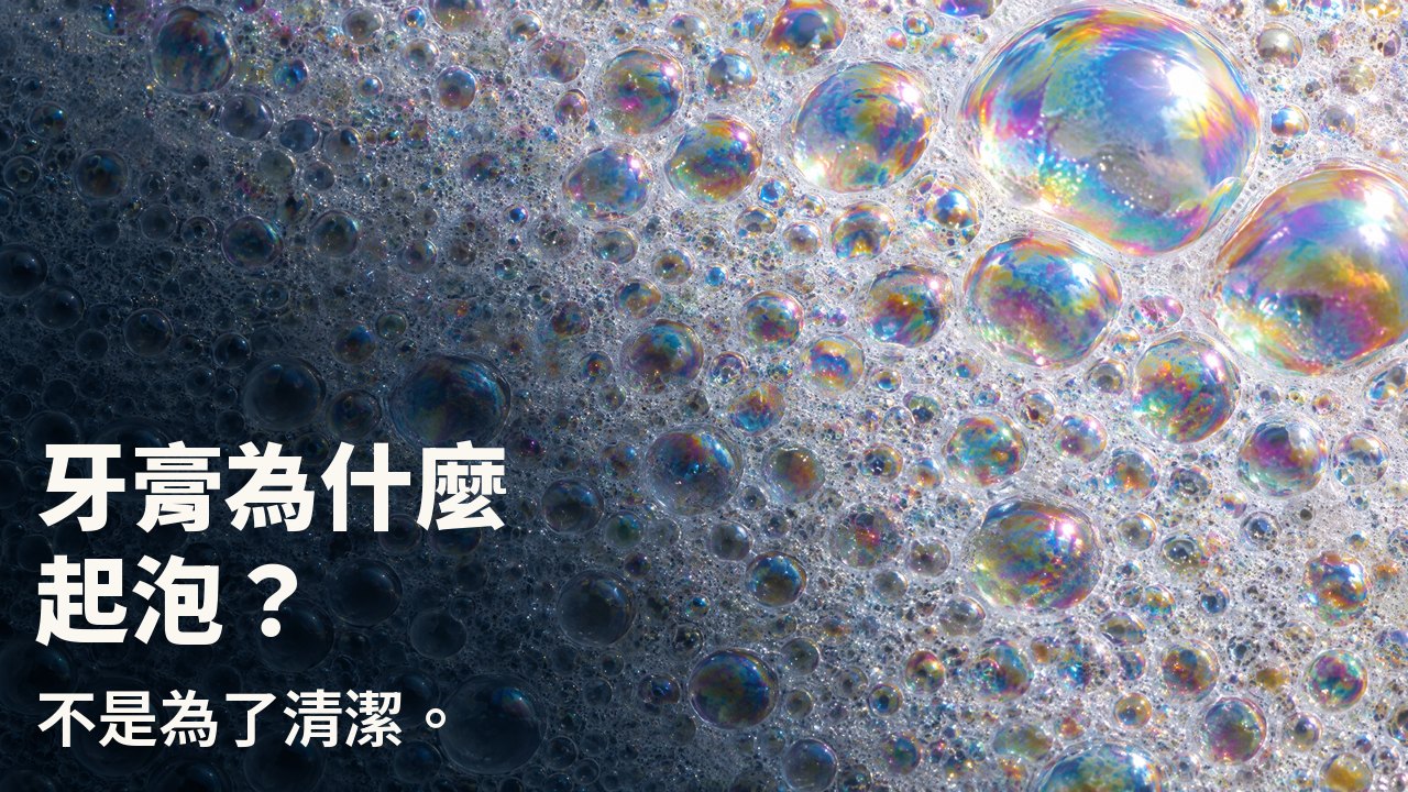 牙膏為什麼起泡? 不是為了清潔。 白色泡沫微距:無數帶彩虹虹彩膜的小泡泡,幾顆大泡泡映著光。