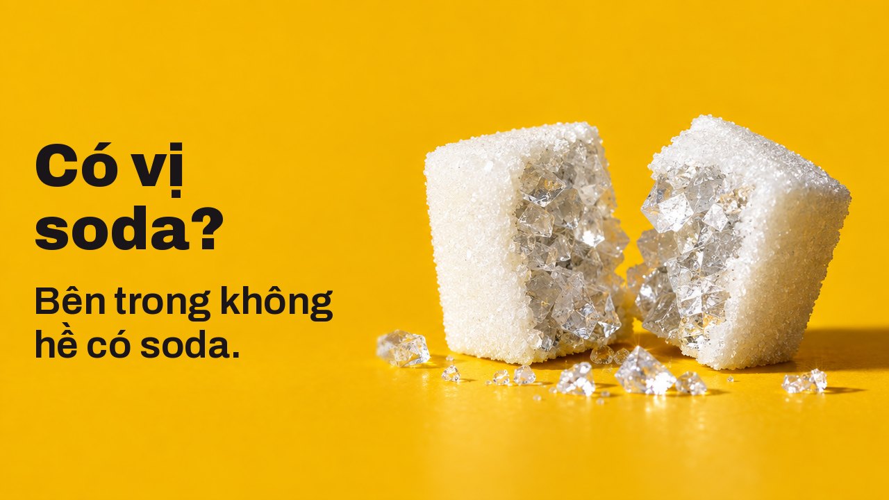 Có vị soda? Bên trong không hề có soda. Cận cảnh rất gần từ ngang mặt bàn trên nền vàng nghệ ấm: một viên đường trắng bị tách làm đôi, và bên trong không phải đường mà là những tinh thể muối lớn óng ánh như thủy tinh.